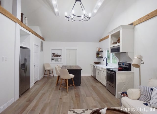 white kitchen, wood island, white beams, living room