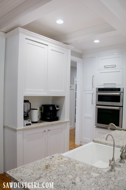 White cabinet, coffee station hutch, built-in double ovens, farmhouse kitchen sink