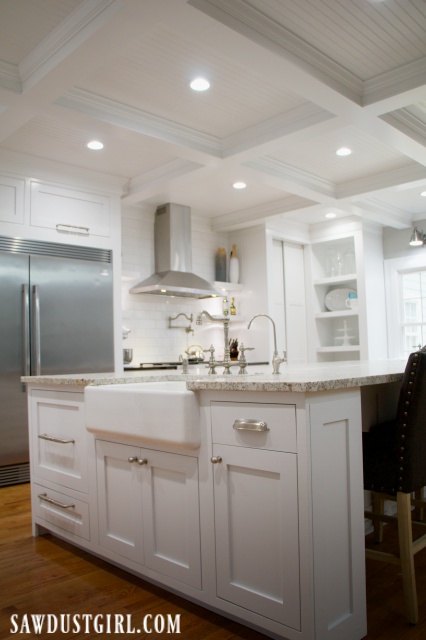 Kitchen with white cabinets and box beam ceiling